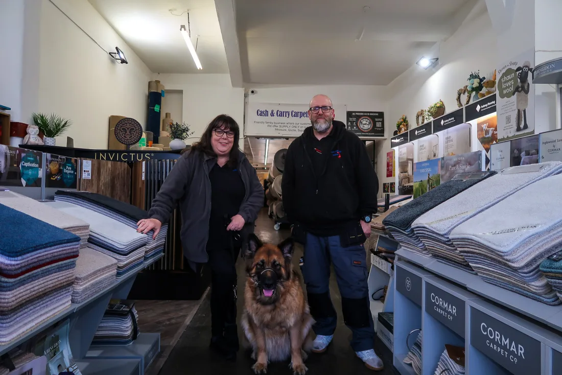 Angie and Kevin, owners of Cash and Carry Carpets, with their dog in the Banbury showroom